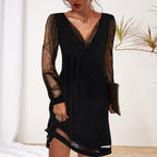 Robe noire élégante avec manches en tulle transparent et paillettes, tenue de soirée chic, femme tenant une pochette, fond minimaliste.