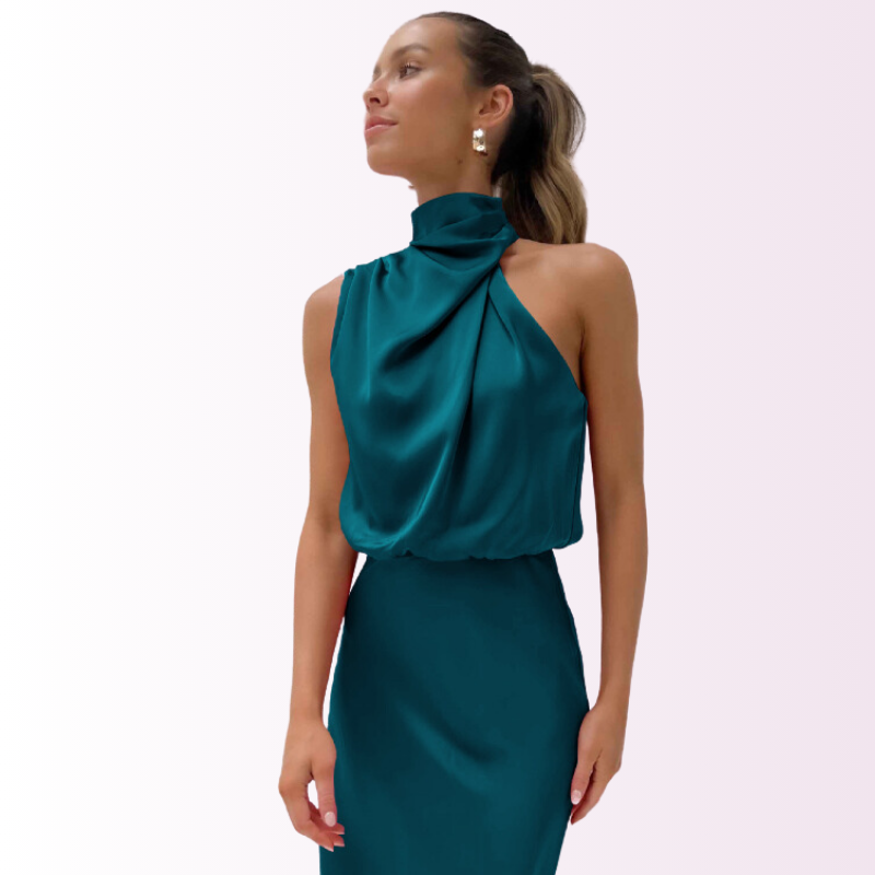 Robe élégante en satin vert émeraude, sans manches, col haut drapé, portée par une femme. Mode féminine chic, tenue de soirée tendance.