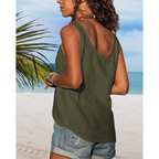 Femme en débardeur vert et short en jean sur plage tropicale, mer turquoise en arrière-plan, bracelets colorés, ambiance estivale et décontractée.