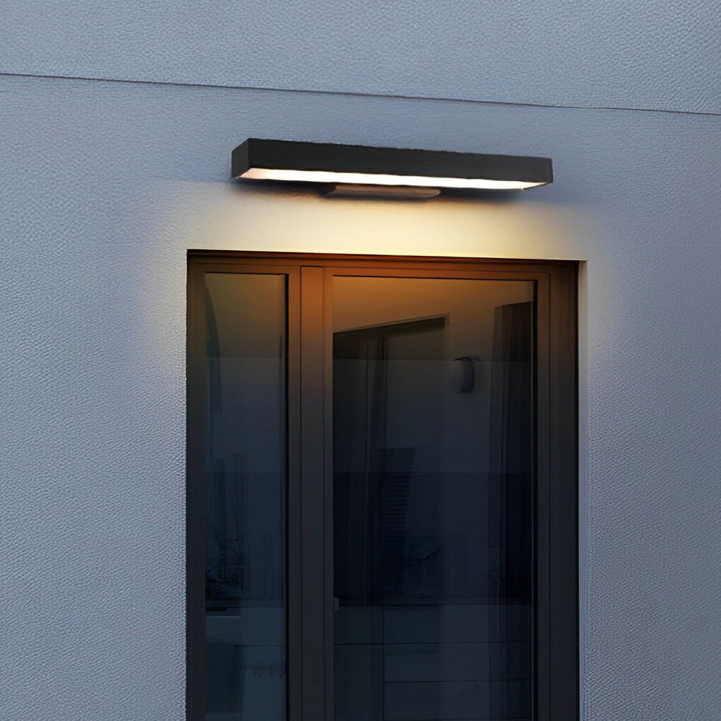 Applique murale moderne noire éclairant une porte vitrée, design minimaliste, éclairage extérieur LED, façade maison contemporaine.