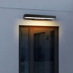 Applique murale moderne noire éclairant une porte vitrée, design minimaliste, éclairage extérieur LED, façade maison contemporaine.