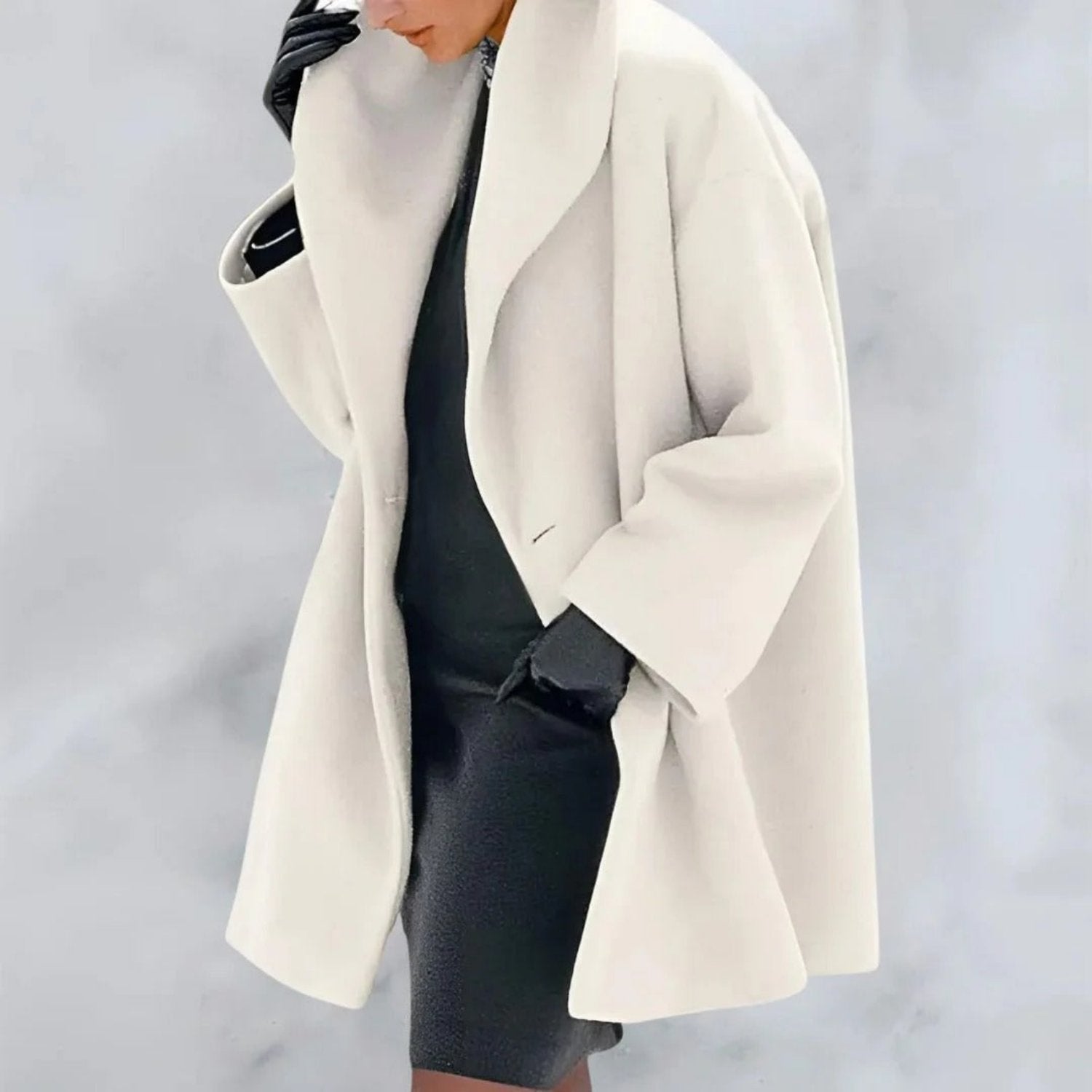 Femme élégante portant un manteau blanc oversize, robe noire et gants en cuir. Mode hiver chic, style minimaliste, tendance vestimentaire.