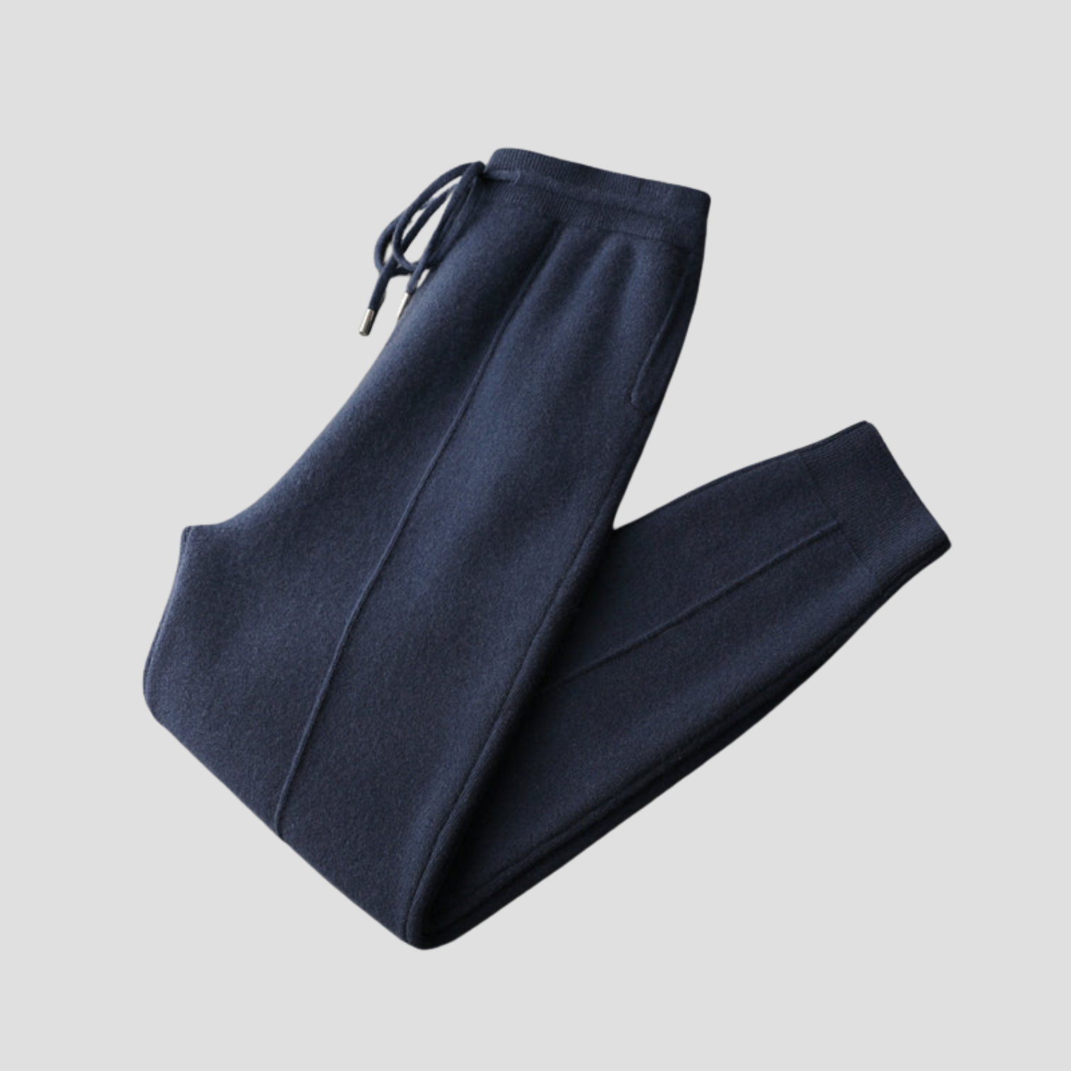 Pantalon de jogging bleu marine en laine, avec cordon de serrage et poches latérales, sur fond gris. Mode décontractée, vêtements confortables.