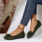 Chaussures ballerines vertes en daim avec nœud, portées avec un jean ajusté. Style décontracté et élégant pour femme. Accessoire mode tendance.