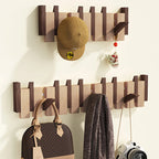 Porte-manteau mural en bois moderne avec casquette, sac à main, appareil photo et écharpe accrochés, design élégant et fonctionnel pour entrée.