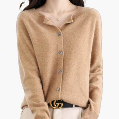 Femme portant un cardigan en laine beige avec boutons, collier délicat et ceinture noire élégante. Mode automne-hiver, style chic et décontracté.