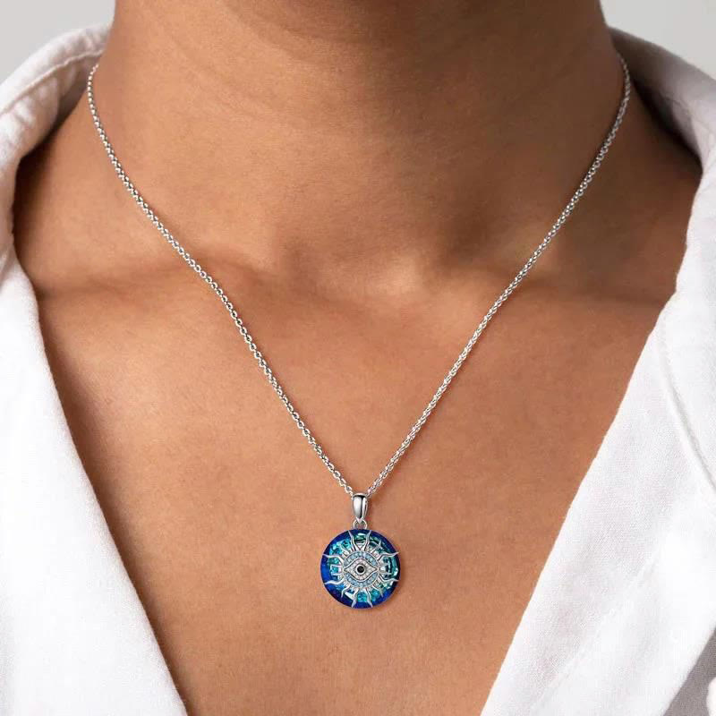 Collier pendentif mandala bleu sur chaîne argentée, porté sur chemise blanche. Bijou élégant, design spirituel, accessoire mode tendance.