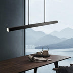 Suspension moderne noire au-dessus d'une table en bois, avec vue sur un lac et montagnes en arrière-plan, design minimaliste et élégant.