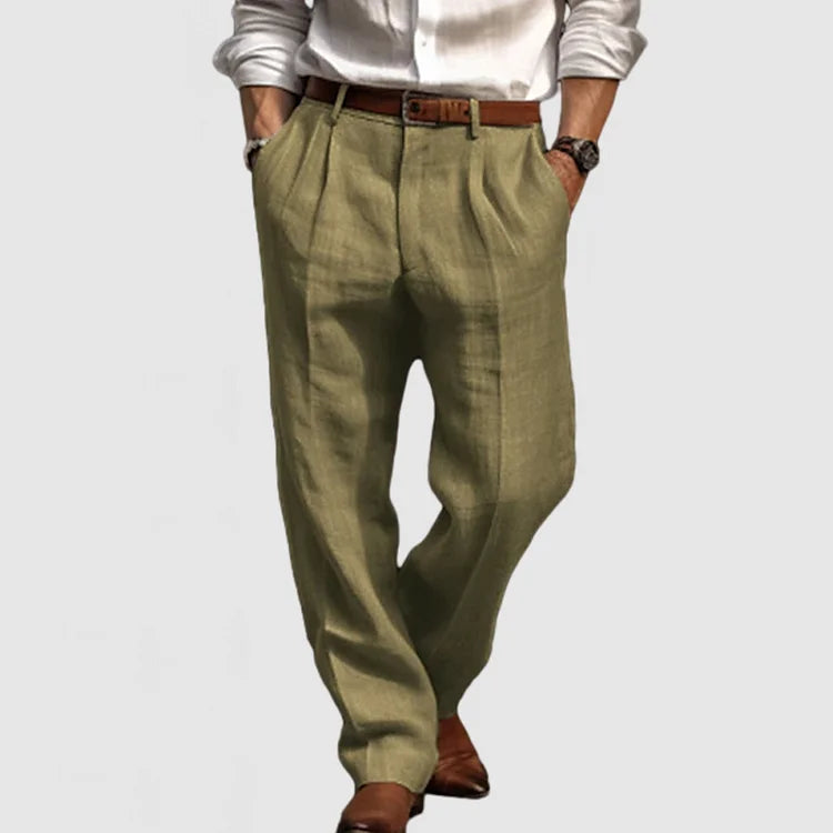 Pantalon en lin vert olive pour homme, coupe ample, ceinture marron, chemise blanche, chaussures marron. Mode masculine élégante et décontractée.