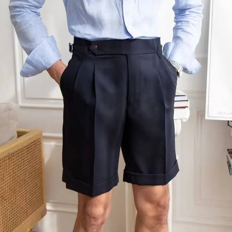 Homme portant un short noir élégant avec une chemise bleue, style chic et moderne, mode masculine, tenue estivale sophistiquée.