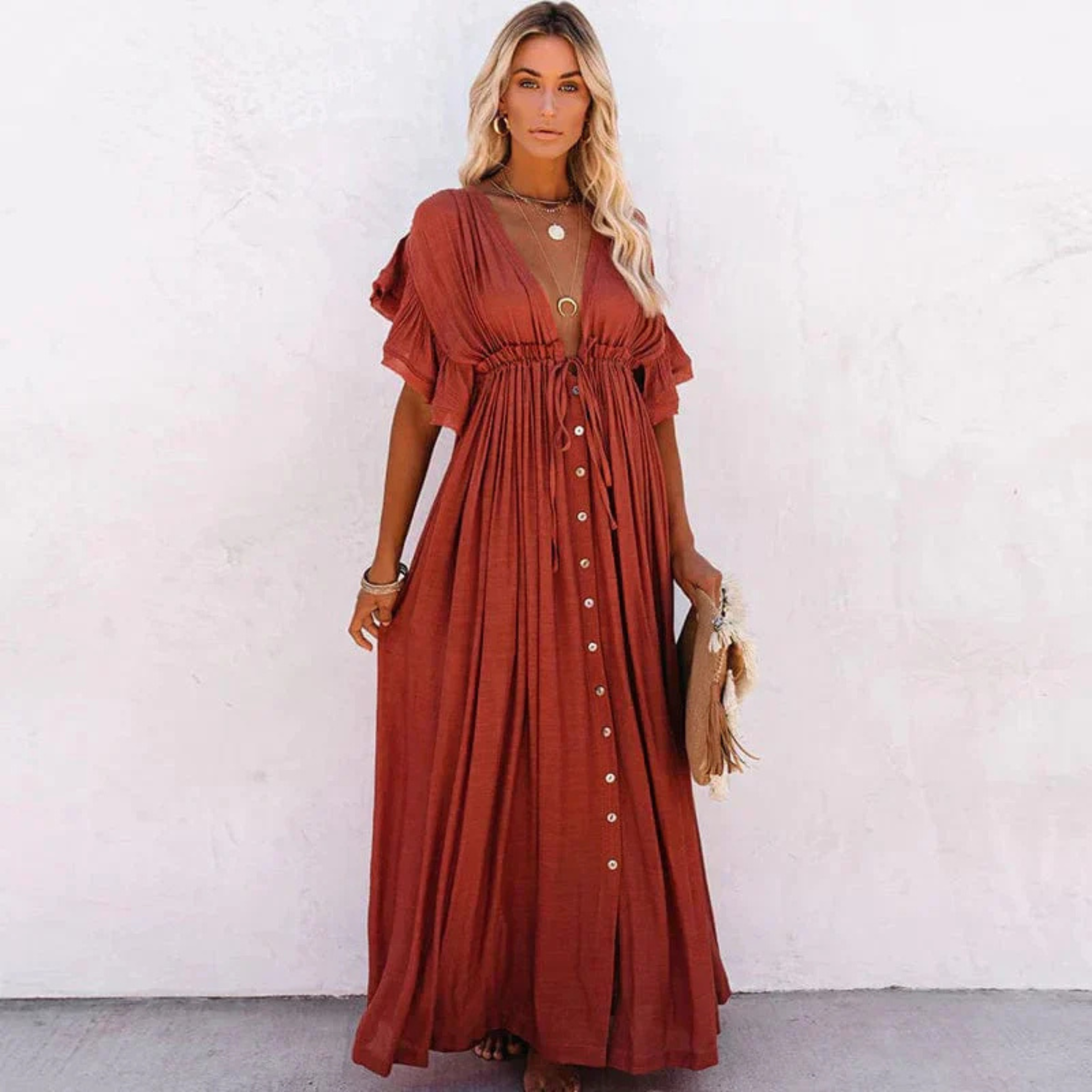 Robe longue bohème rouge avec boutons, manches courtes et col en V, portée par une femme blonde. Mode estivale chic et décontractée.