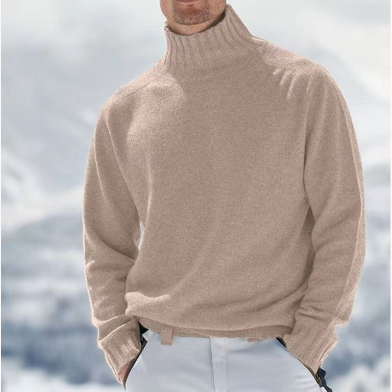 Homme portant un pull col roulé beige en laine, style hivernal élégant, fond enneigé. Mode masculine, vêtements chauds, tendance hiver.