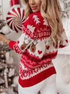 Femme portant un pull de Noël rouge et blanc avec motifs de rennes et sapins, devant un décor festif. Mode hiver, vêtements de fête.