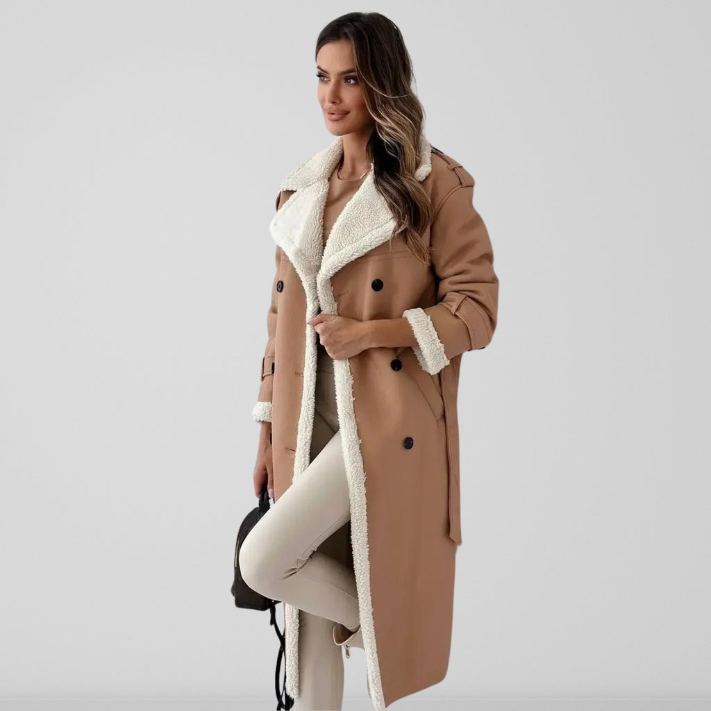 Femme portant un manteau camel à doublure en fausse fourrure blanche, tenue élégante d'hiver, mode féminine chic, fond gris clair.