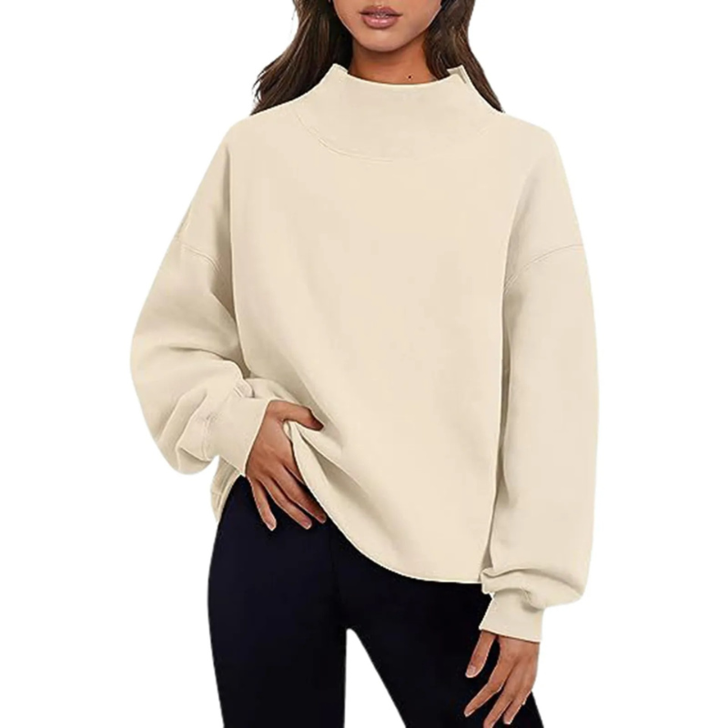 Femme portant un pull beige à col montant, manches longues, associé à un pantalon noir. Mode décontractée, tendance automne-hiver.