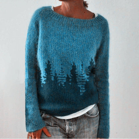 Pull bleu en laine avec motif de forêt, manches longues, col rond, porté par une personne. Mode automne-hiver, style décontracté et confortable.