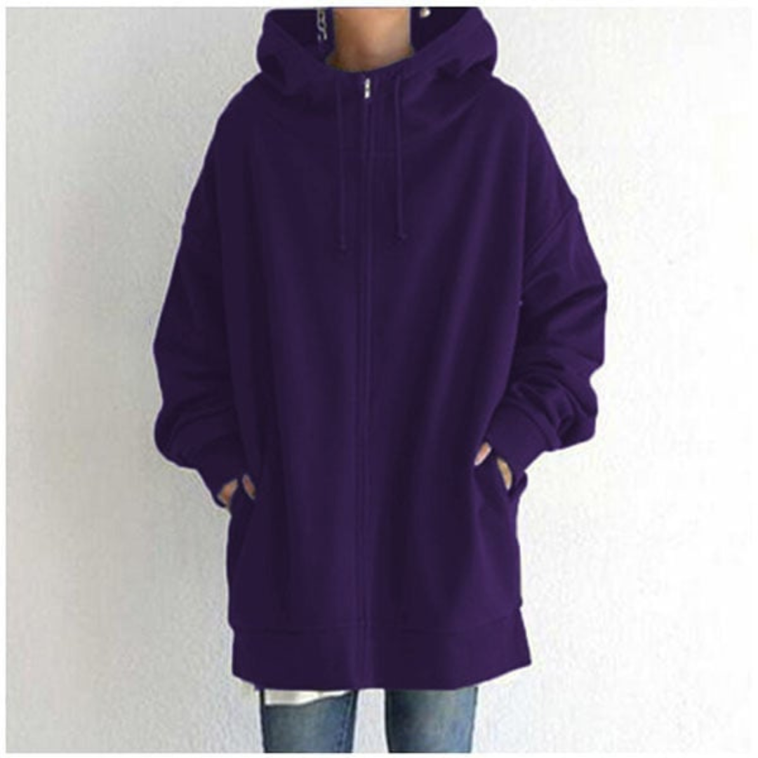Veste à capuche violette unie, ample et confortable, avec fermeture éclair, poches avant, portée par une personne en jean. Mode décontractée tendance.
