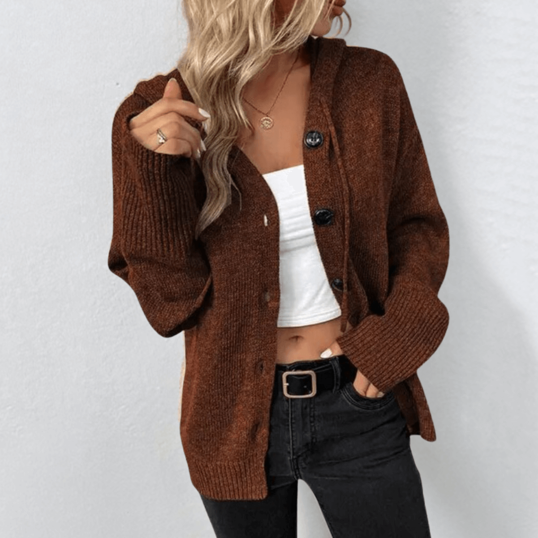 Femme portant un cardigan marron en maille avec boutons, t-shirt blanc, jean noir. Mode automne, style décontracté, tendance vêtements femme.