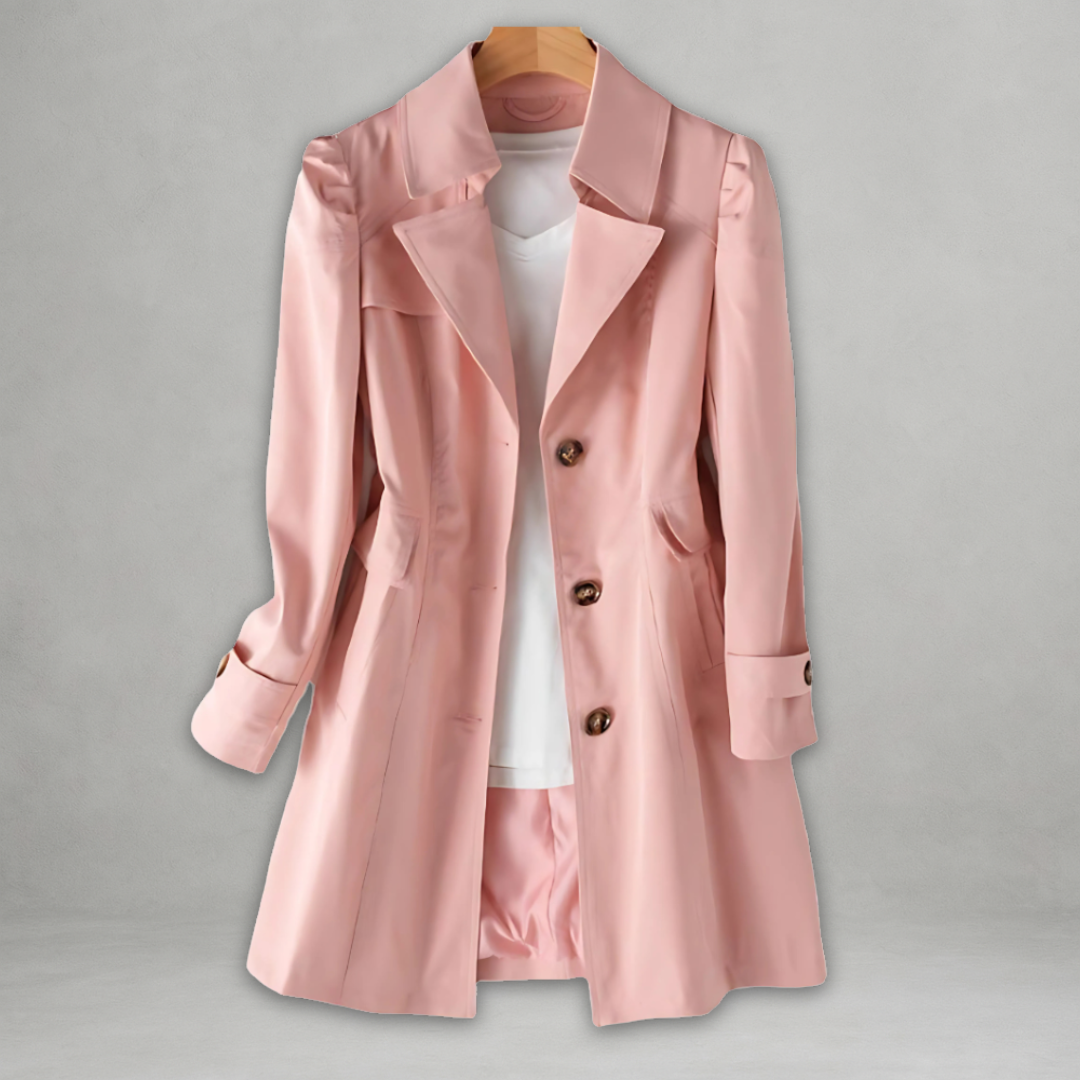 Manteau trench rose élégant pour femme, avec boutons marron, suspendu sur cintre, sur fond gris. Mode féminine, vêtement chic, tendance automne.