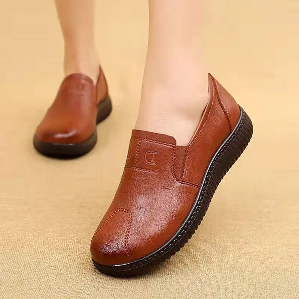 Chaussures en cuir marron pour femme, semelle noire antidérapante, design élégant et confortable, idéales pour un usage quotidien.