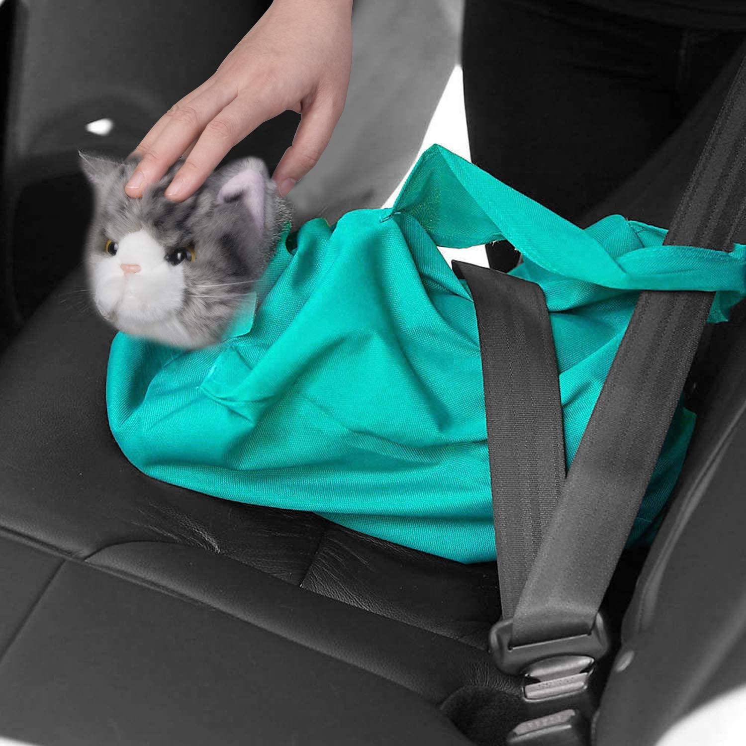 Main en train de placer un chat en peluche gris dans un sac turquoise sur un siège de voiture. Jouet sécurisé par une ceinture de sécurité.