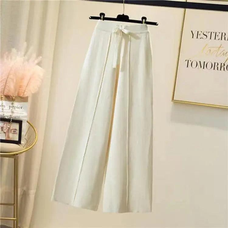 Pantalon large blanc élégant suspendu sur cintre, style moderne et chic, idéal pour tenues décontractées ou professionnelles. Mode féminine tendance.