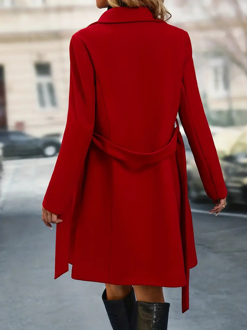 Manteau rouge élégant pour femme, coupe longue avec ceinture, idéal pour l'hiver. Mode urbaine chic, arrière-plan flou de rue.