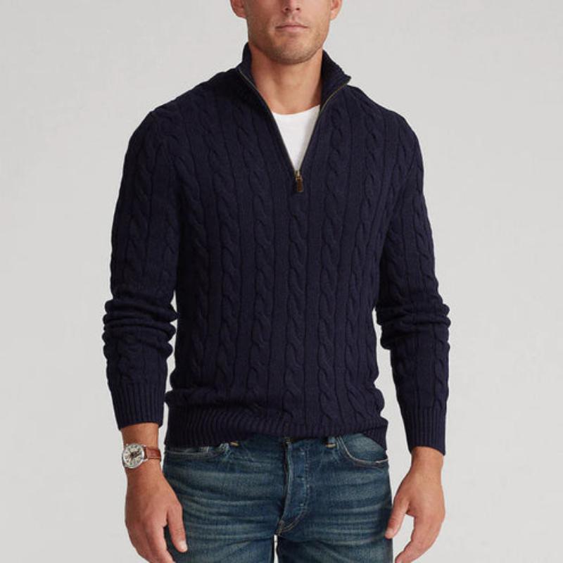 Homme portant un pull bleu marine à col zippé, motif torsadé, avec un jean. Mode masculine élégante et décontractée, style automne-hiver.