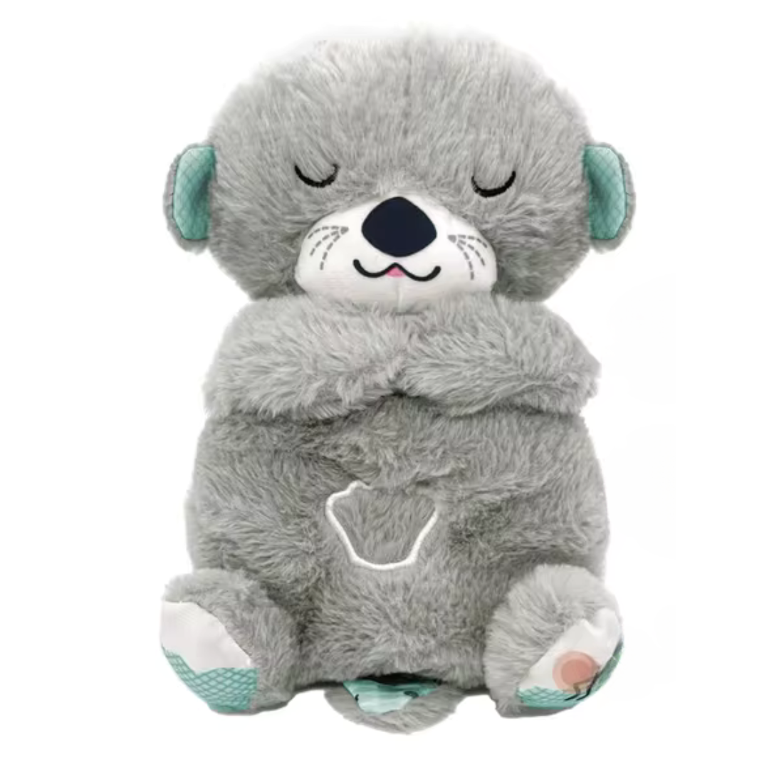 Peluche loutre grise douce avec oreilles et pattes turquoise, yeux fermés, motif cœur sur le ventre. Jouet câlin pour enfants.