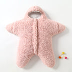 Combinaison bébé étoile en polaire rose, douce et chaude, avec capuche. Idéale pour l'hiver. Accessoires colorés à côté.