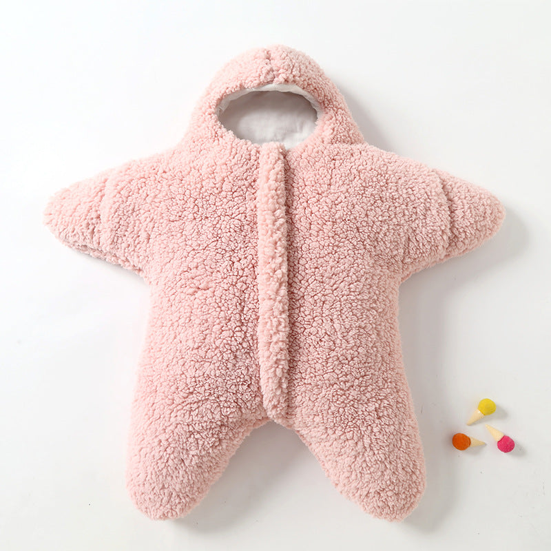 Combinaison bébé étoile en polaire rose, douce et chaude, avec capuche. Idéale pour l'hiver. Accessoires colorés à côté.