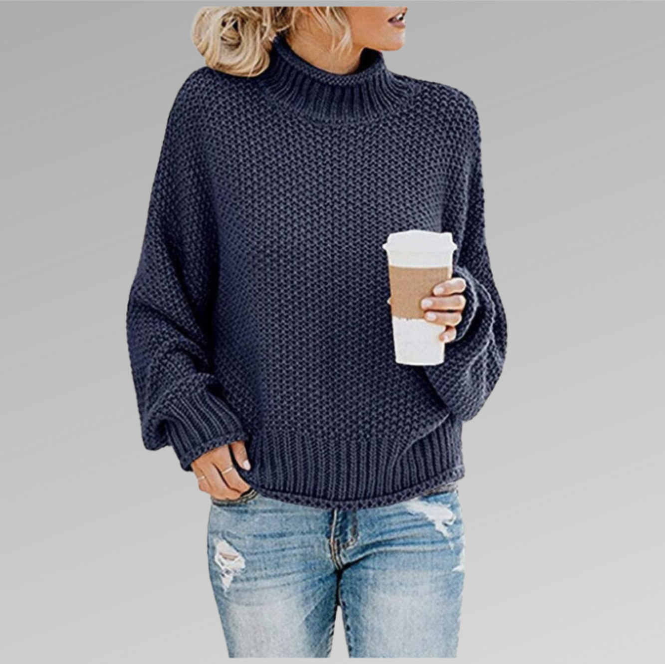 Femme en pull en maille bleu, tenant un gobelet de café, portant un jean déchiré. Mode décontractée automne-hiver, style confortable et tendance.