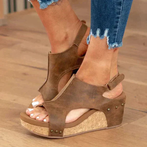 Sandales compensées en cuir marron avec semelle en liège, portées avec un jean déchiré. Chaussures d'été tendance pour femmes.