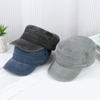 Trois casquettes militaires en denim gris, bleu et noir posées sur une table blanche, avec une plante verte en arrière-plan. Accessoires mode tendance.