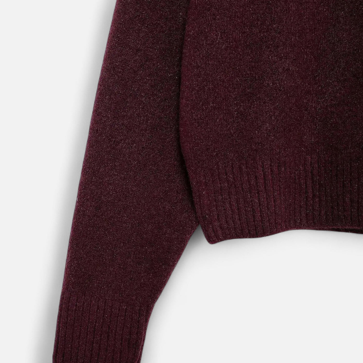 Manche de pull en laine bordeaux, texture douce et côtelée, mode automne-hiver, vêtement chaud et élégant pour homme ou femme.
