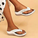 Sandales compensées blanches pour femme, design perforé, portées avec une robe à pois. Chaussures d'été élégantes et confortables.