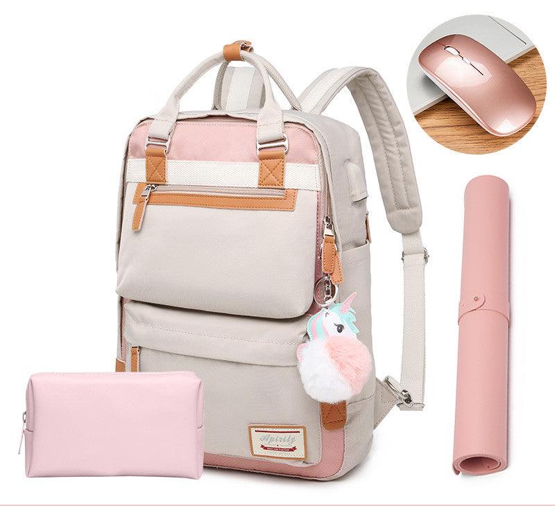 Sac à dos beige et rose avec porte-clés licorne, accompagné d'une trousse rose, d'un tapis de souris rose et d'une souris sans fil rose.