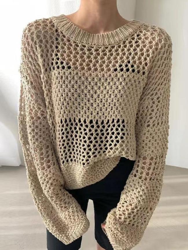 Pull en maille ajourée beige, manches longues, style décontracté, porté par une personne. Mode automne, tendance tricot, look moderne et élégant.
