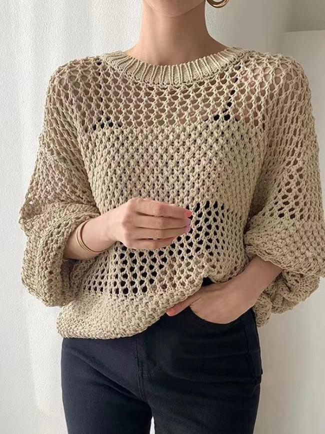 Femme portant un pull en maille beige ajouré, manches longues, sur fond blanc. Mode automne, style décontracté, tendance tricot.