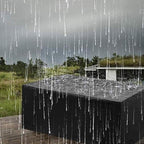 Baignoire extérieure moderne noire sous la pluie, entourée de verdure et ciel nuageux. Design contemporain, relaxation en plein air.