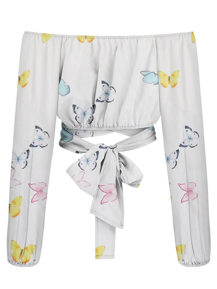 Haut court à manches longues, motif papillons colorés, col bardot, nœud à la taille, style bohème, mode féminine tendance, fond blanc.