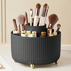 Organisateur de maquillage noir avec pinceaux et rouges à lèvres, design moderne, pieds dorés, idéal pour rangement cosmétique sur coiffeuse élégante.