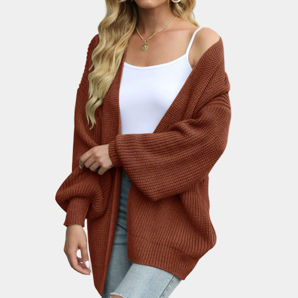 Femme portant un cardigan en maille marron, débardeur blanc et jeans déchirés. Mode automne, style décontracté, tendance vêtements femme.