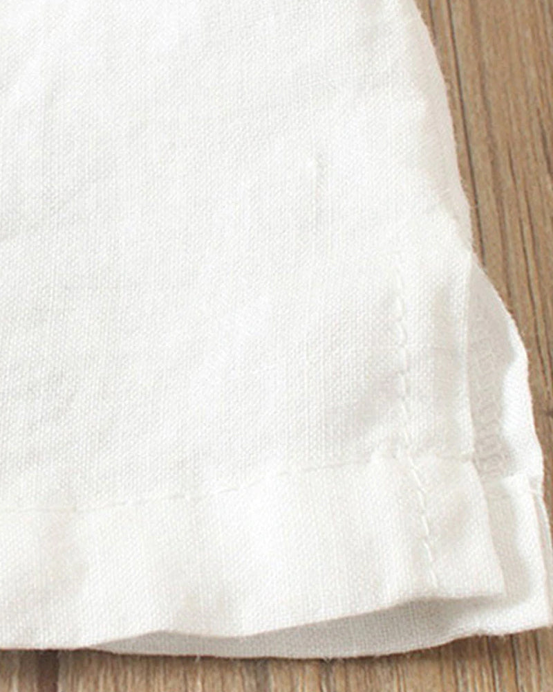 Ourlet de tissu en lin blanc sur plancher en bois, texture douce et naturelle, couture visible, idéal pour décoration intérieure ou vêtements.