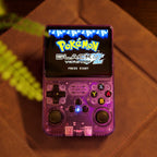 Console de jeu rétro violette avec écran affichant "Pokémon Black Version 2". Boutons colorés visibles. Fond en cuir marron.