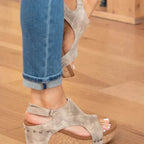 Jeans bleus et sandales beiges en cuir avec talon compensé sur parquet en bois. Mode féminine, chaussures d'été confortables et élégantes.