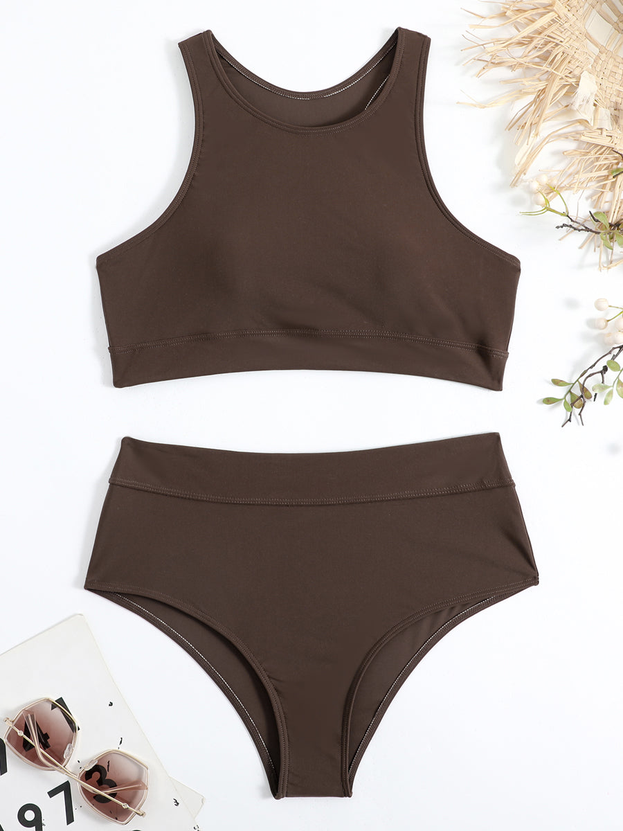 Maillot de bain deux pièces marron, style sportif, avec haut à col haut et bas taille haute. Accessoires d'été en arrière-plan.