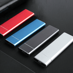 Quatre clés USB colorées (rouge, bleue, noire, argentée) alignées sur une surface noire texturée. Accessoires de stockage de données modernes.