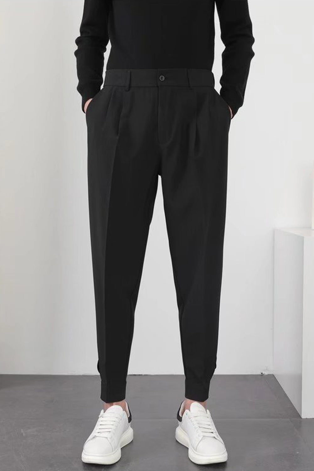 Pantalon noir homme élégant, coupe moderne, avec poches, porté avec des baskets blanches. Mode masculine tendance, style décontracté chic.
