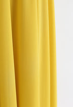 Rideau jaune vif en tissu texturé, drapé élégamment. Décoration intérieure moderne, accent vibrant, design minimaliste.